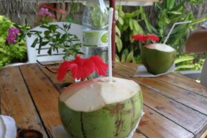 two fresh coconuts with a straw on the table