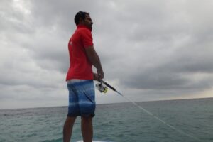 a fisherman with a rod retrieves the bait back to himself