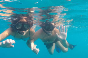snorkeling man and woman holding by hands