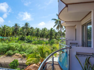 View from the balcony over the adjacent balconies to the natural greenery with palm trees