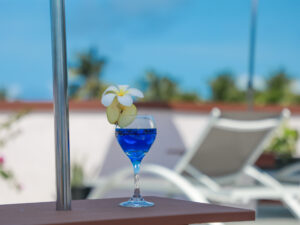 Blue drink with pear and white flower on the table under the umbrella